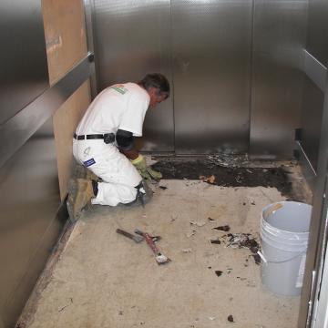 Hand-grinding elevator floor in prep for resinous surface.